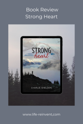 Cover Picture is the book cover for Strong Heart. The cover and frame show cloudy skies and a forest of conifers. The background color is gray. The title is Book Review Strong Heart. At the bottom is the website www.life-reinvent.com